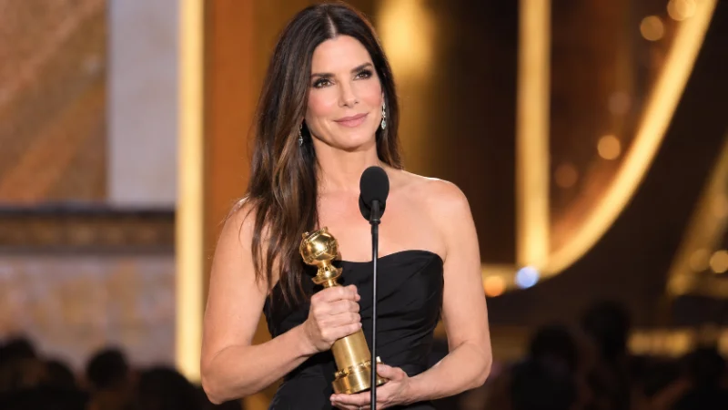 Sandra Bullock holding an award on stage